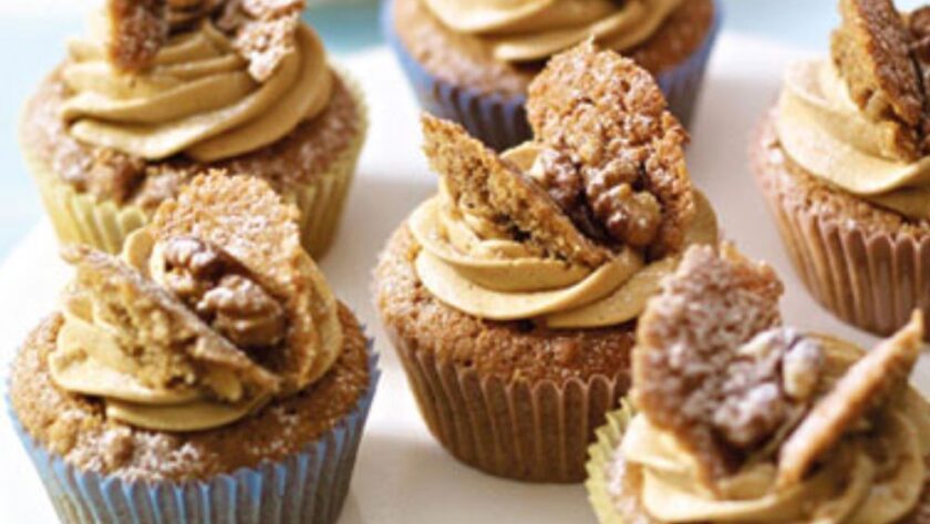 These coffee and walnut cupcakes are rich, nutty, and perfect for any coffee lover. They have a soft and fluffy texture, a delicious coffee flavour, and crunchy walnuts in every bite. Topped with smooth coffee buttercream and a classic butterfly decoration, they are great for afternoon tea, birthdays, or special occasions. In this recipe Mary Berry uses the all-in-one method, making it super easy and foolproof—just mix everything in one bowl and bake! Whether you’re making them for a gathering or just to enjoy with a cup of coffee, these cupcakes are a guaranteed hit. Ingredients Needed For the cupcakes: 2 tsp instant coffee granules 115g (4oz) butter (room temperature) or baking spread (at least 70% fat) 115g (4oz) caster sugar 115g (4oz) self-raising flour 1 tsp baking powder 2 large eggs 45g (1 1/2oz) walnut halves, finely chopped For the icing: 2 tsp instant coffee granules 350g (12oz) icing sugar, plus extra for dusting 175g (6oz) butter (room temperature) 6 walnut halves, halved lengthways How To Make Coffee and Walnut Cupcakes Prepare the oven and coffee: Preheat the oven to 180°C (fan 160°C/350°F/Gas 4). Line a 12-hole shallow bun tin with paper cases. In a small bowl, dissolve the coffee granules in 2 teaspoons of hot water, then set aside to cool. Make the cake batter: In a large bowl, combine the butter, caster sugar, self-raising flour, and baking powder. Add the eggs and the cooled coffee mixture. Using an electric hand whisk or a wooden spoon, beat until the mixture is smooth and creamy. Stir in the chopped walnuts. Bake the cupcakes: Divide the batter evenly between the paper cases. Bake for 15–20 minutes until the cupcakes are well-risen and firm to the touch. Transfer them to a wire rack and let them cool completely. Make the coffee icing: In a small bowl, dissolve the coffee granules in 2 teaspoons of hot water and let it cool. Sift the icing sugar into a large bowl. Add the butter and cooled coffee mixture, then beat until smooth and fluffy. Decorate the cupcakes: Using a sharp knife cut a small circle from the top of each cupcake and cut each piece in half to create “butterfly wings”. Spoon the icing into a piping bag fitted with a star nozzle and pipe a swirl into the centre of each cupcake. Place the reserved cake pieces on top to resemble wings, then add a walnut quarter between them. Lightly dust with icing sugar before serving. Recipe Tips Use soft butter: Let the butter sit at room temperature for 2–3 hours before baking to ensure a smooth mixture. Even baking: Fill the paper cases evenly so that all cupcakes rise at the same rate. Smooth icing: Sift the icing sugar before mixing for a lump-free, creamy texture. No piping bag? Simply spread the icing on top with a butter knife or spoon for an easy alternative. How To Store Leftovers Storing in the fridge: Place the cupcakes in an airtight container and store them in the fridge for up to 3 days. Bring them to room temperature before serving for the best texture. Freezing without icing: Store uniced cupcakes in a freezer-safe container for up to 3 months. Thaw them at room temperature before decorating. Freezing with icing: If freezing with icing, arrange the cupcakes in a single layer inside a container and freeze for up to 2 months. Allow them to thaw in the fridge overnight, then let them sit at room temperature before serving. Try More Recipes: Mary Berry Chocolate Cupcakes Mary Berry Ginger Cupcakes Mary Berry Lemon Cupcakes Mary Berry Carrot Cupcakes