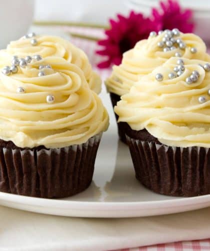 Two decorated chocolate cupcakes on plate
