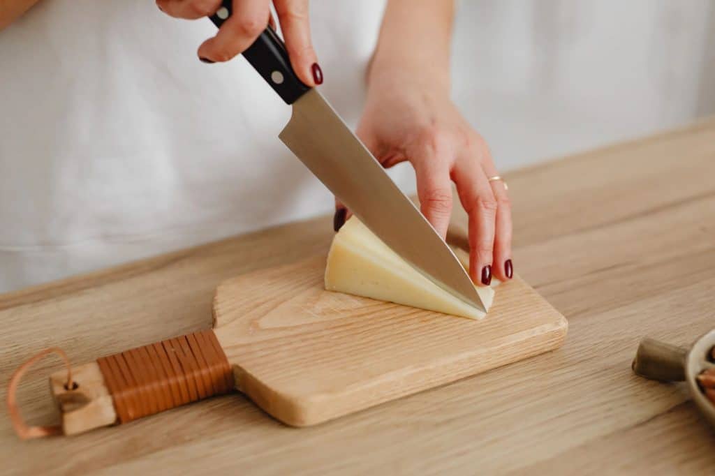 Slicing cheese on a wooden board