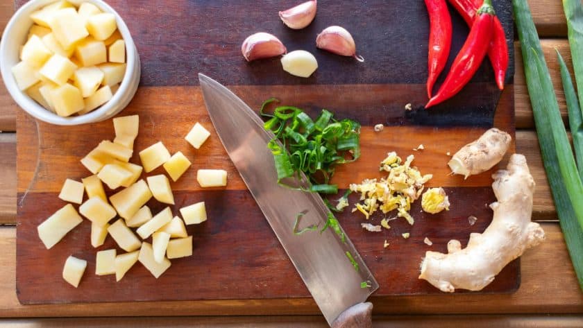 Chopped vegetables and herbs on board