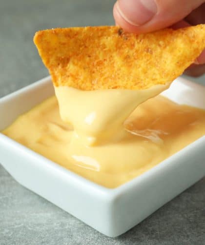 Chip dipping into cheese sauce