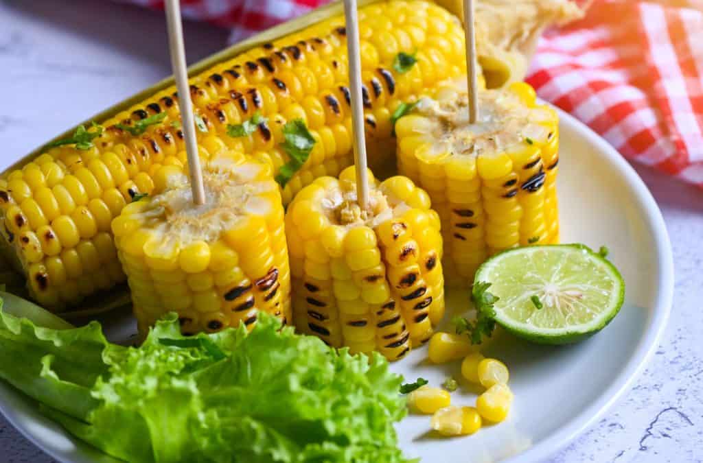 Grilled corn on plate with lime