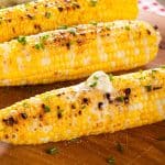 Grilled corn on wooden cutting board
