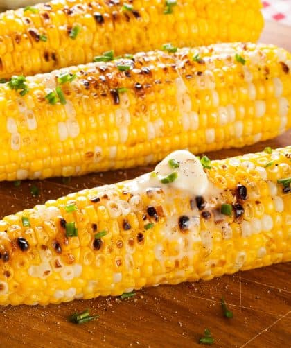 Grilled corn on wooden cutting board