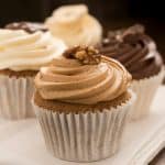 Three frosted cupcakes on napkin