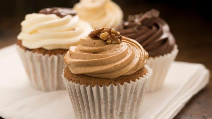 Three frosted cupcakes on napkin