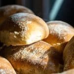 Close-up of freshly baked bread rolls dusted with flour, perfect for bread recipes and baking at hom.