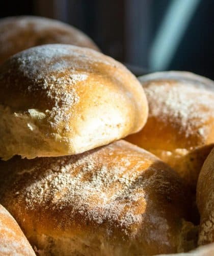 Close-up of freshly baked bread rolls dusted with flour, perfect for bread recipes and baking at hom.