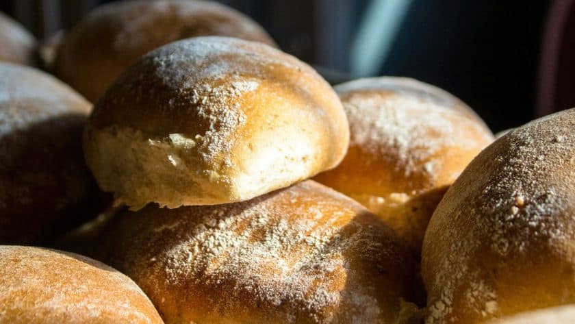 Close-up of freshly baked bread rolls dusted with flour, perfect for bread recipes and baking at hom.