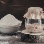 Jar of sourdough starter and flour