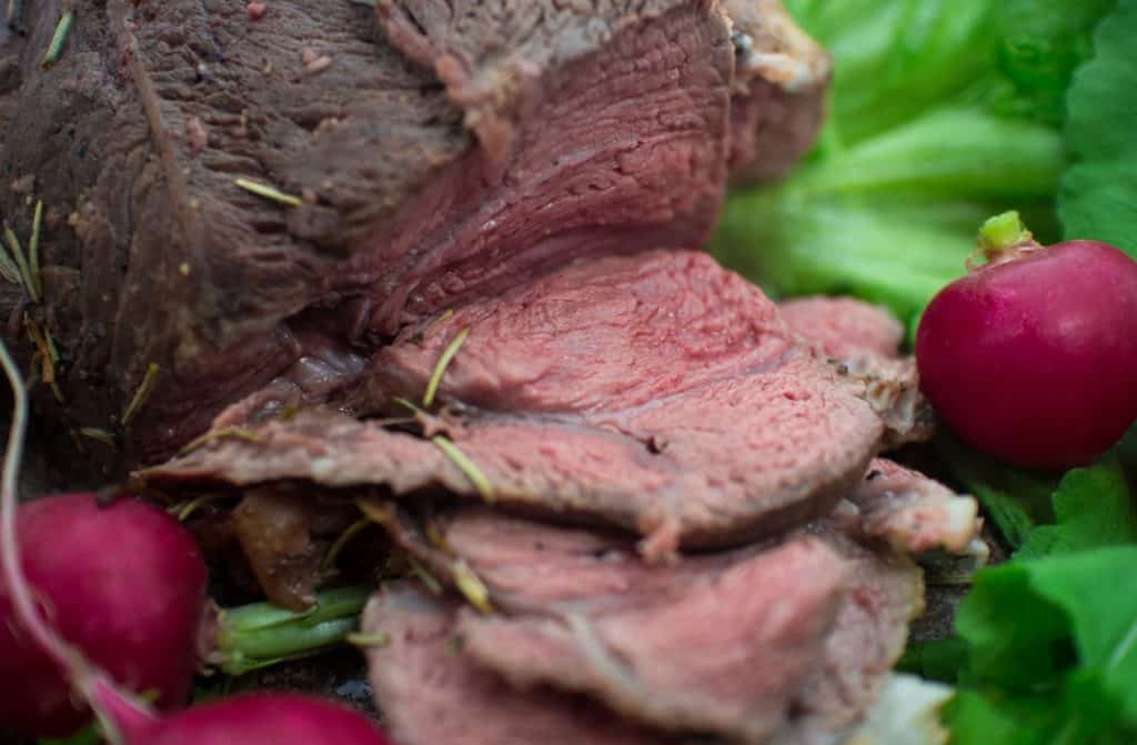 Sliced venison with fresh vegetables.